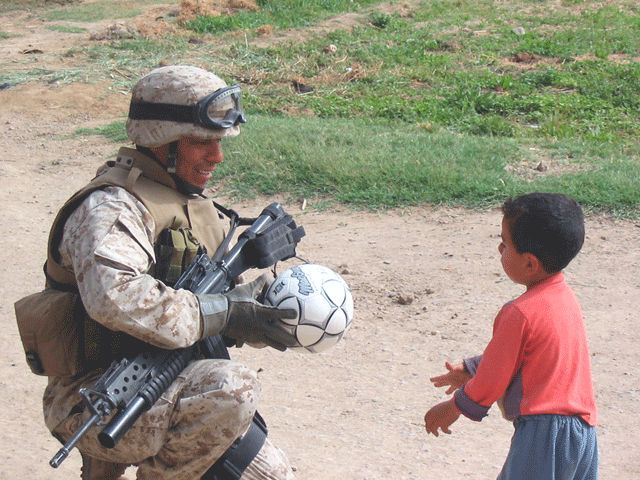 Marines giving a soccer ball to Iraki kid